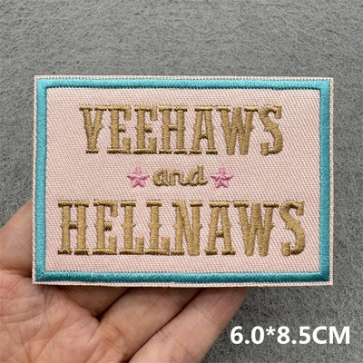 Embroidered patch with 'YEEHAWS and HELLNAWS' text held by a hand on a gray background.