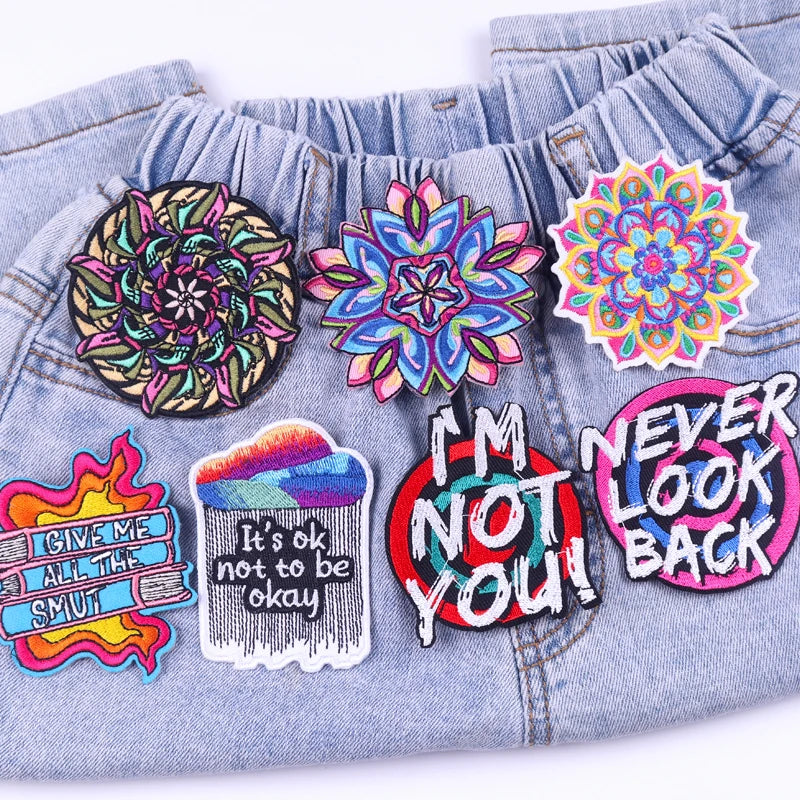 Colorful patches on a denim jacket with various designs and text.