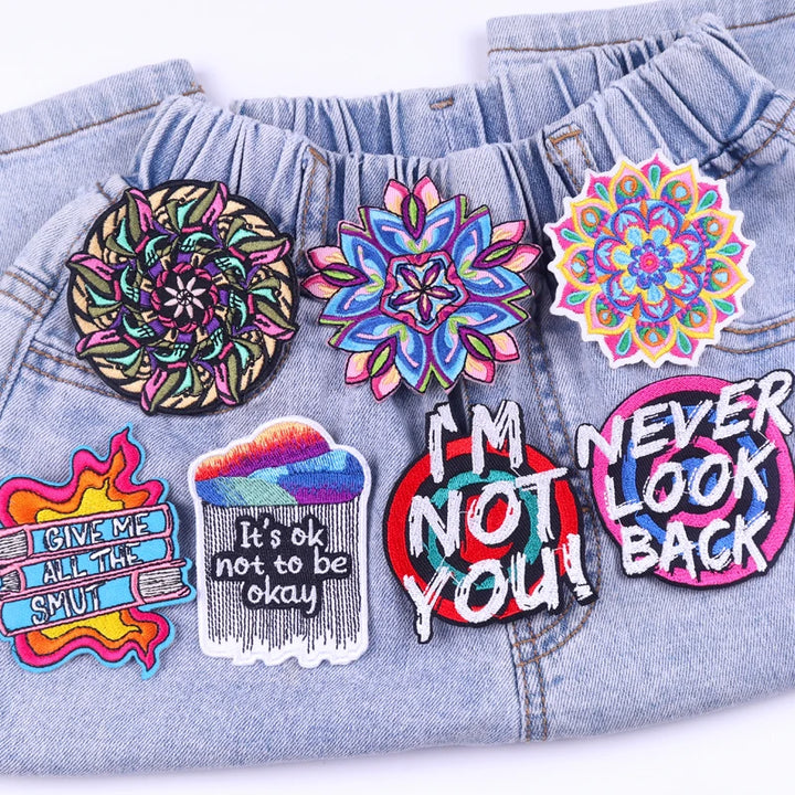 Colorful patches on a denim jacket with various designs and text.