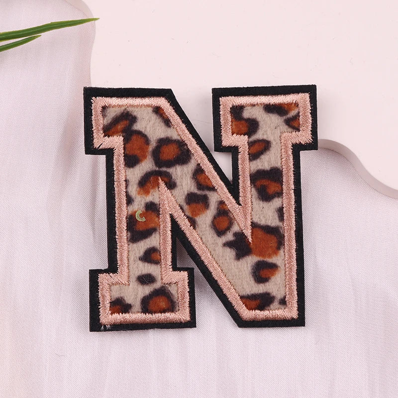Leopard print letter 'N' patch on a light fabric background