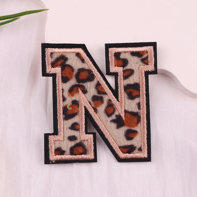 Leopard print letter 'N' patch on a light fabric background