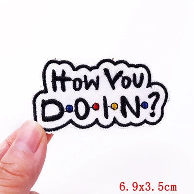 Text patch with 'How You Doin?' design held by a hand on a white background