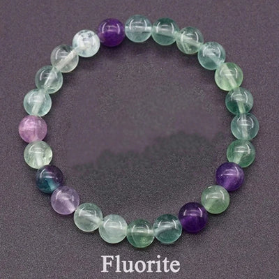 Beaded bracelet with purple and green fluorite stones on a dark background