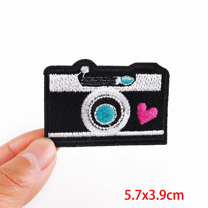 Camera-shaped patch with a heart on a white background
