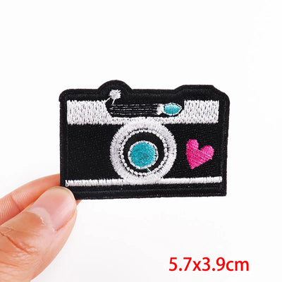 Camera-shaped patch with a heart on a white background