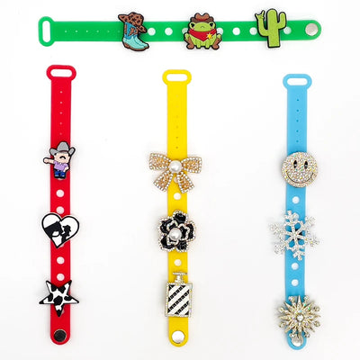 Colorful wristbands with various charms on a white background