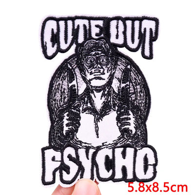 Embroidered patch with text 'Cute But Psychic' held by a hand on a white background