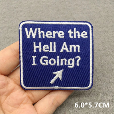 Embroidered patch with text 'Where the Hell Am I Going?' held in a hand against a gray background.