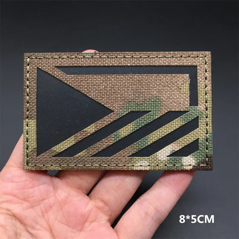 Chez republic flag camouflage patch held in a hand against a dark background