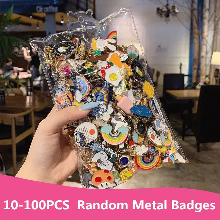 Hand holding a clear package of colorful metal badges with a blurred indoor background.