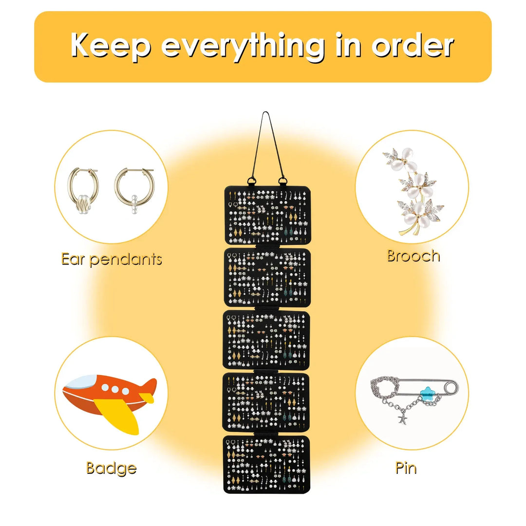 Black hanging organizer with compartments for earrings, brooches, badges, and pins on a yellow background.