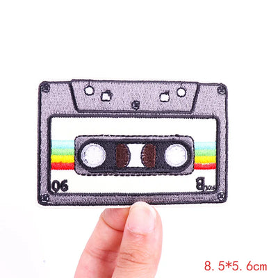 Cassette tape patch held by a hand with a white background