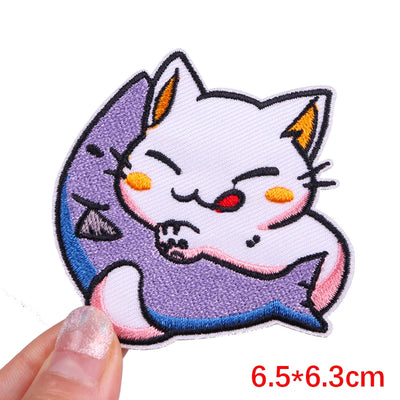 Embroidered patch of a cat-like creature with a fish on a white background