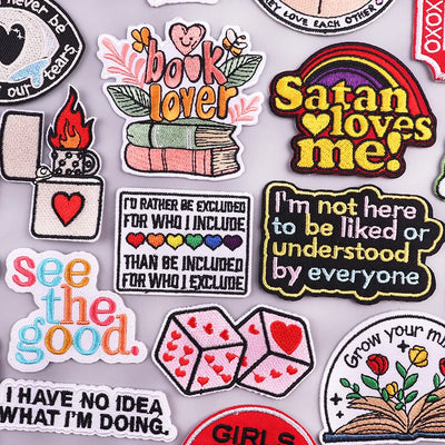 Collection of colorful patches with various messages and designs on a gray background