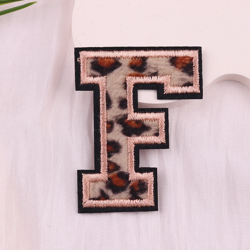 Leopard print letter 'F' patch on a white fabric background