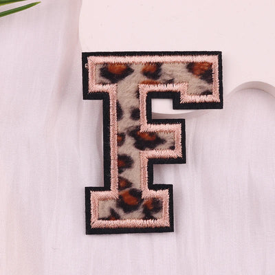 Leopard print letter 'F' patch on a white fabric background