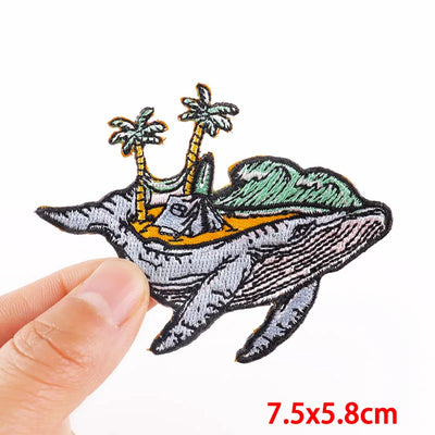 Patch of a whale with a tropical island design held by a hand, with size '7.5x5.8cm' displayed.