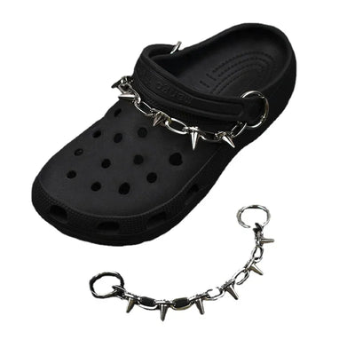 Black clog shoe with metal chain and spikes on a white background