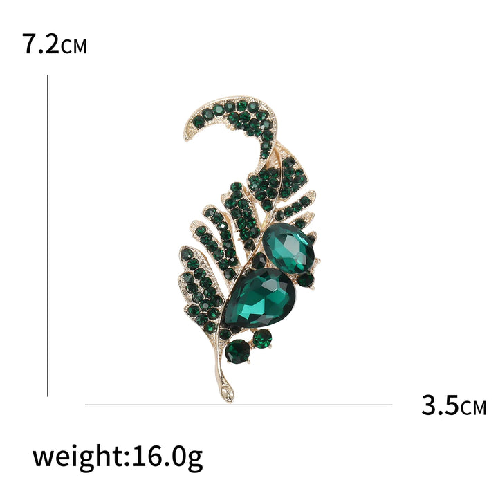 Brooch with green gemstones and gold accents, shown with measurements and weight on a white background.