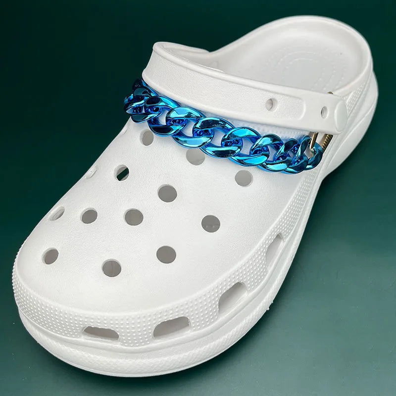 White clog shoe with a blue chain around the ankle on a green background