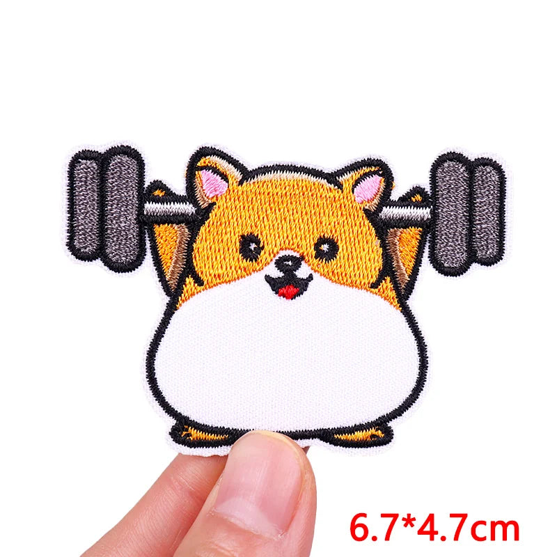 Embroidered patch of a dog lifting weights held by a hand, with dimensions displayed.