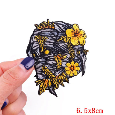 Floral patch held by a hand with a white background