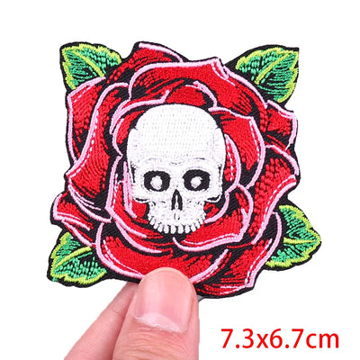 Embroidered patch with skull and red rose held by a hand, size 7.3x6.7cm.