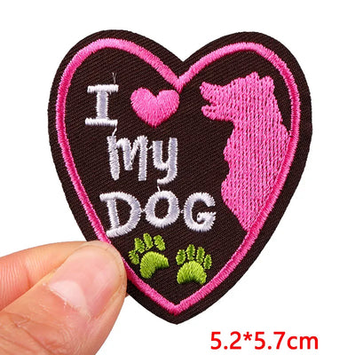 Heart-shaped patch with 'I ❤️ my dog' text and pink border held by a hand.