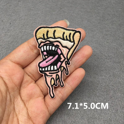Hand holding a pizza slice with a face design against a gray background