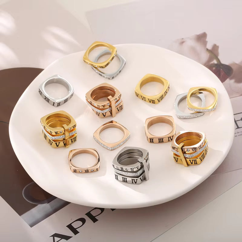 Collection of gold, silver, and rose gold rings on a white plate.
