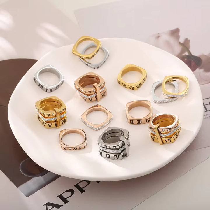 Collection of gold, silver, and rose gold rings on a white plate.