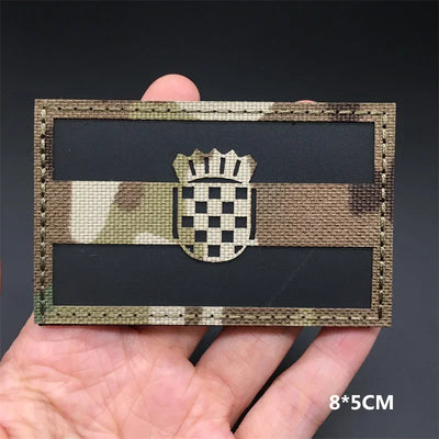 Croatia flag Camouflage patch held in a hand against a dark background