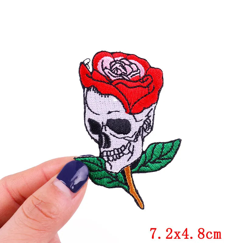 Patch with skull and red rose held by a hand on a white background