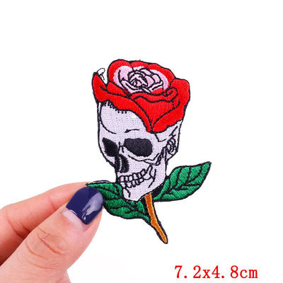 Patch with skull and red rose held by a hand on a white background