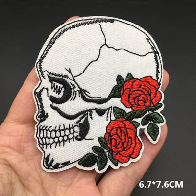 Skull patch with roses held in a hand against a dark background