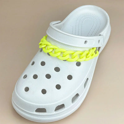 White sandal with a neon yellow chain design on a beige background