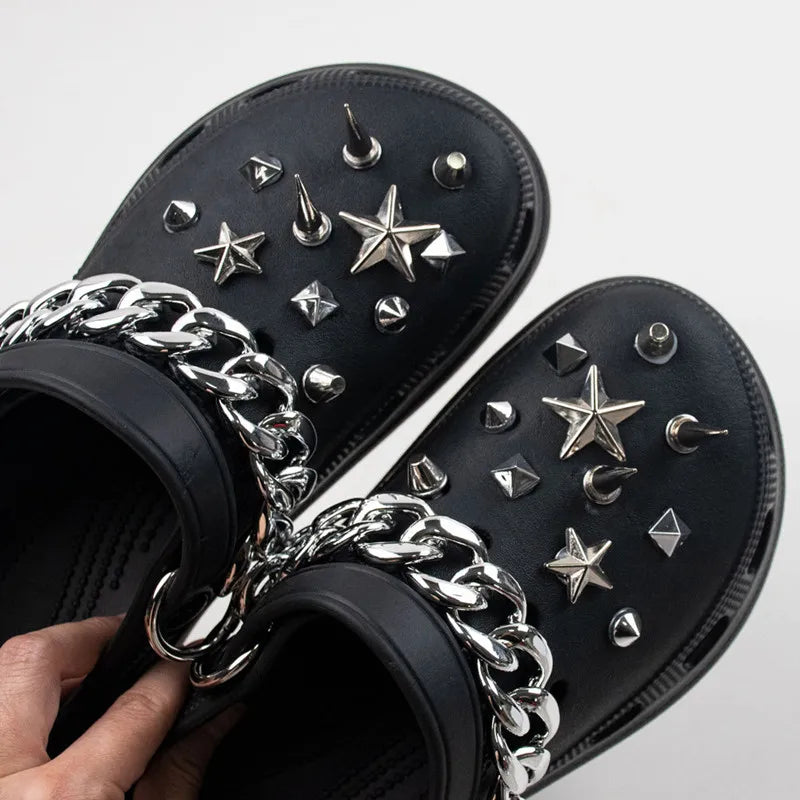 Black sandals with silver Rivet Shoe Charms and chains on a light gray background