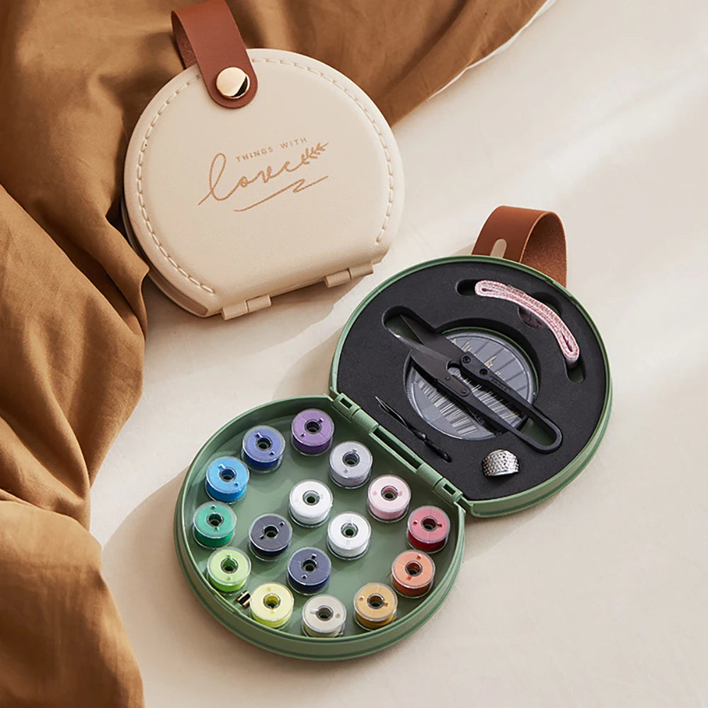 Compact mini travel sewing kit case with colorful thread spools needles and repair tools