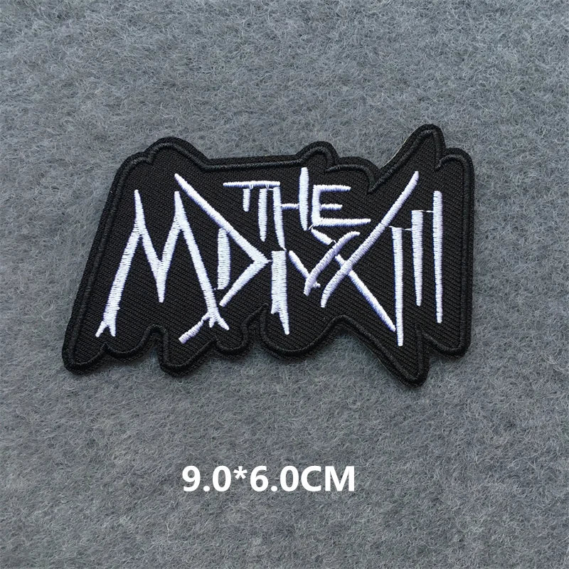 Black and white logo patch with text on a gray background