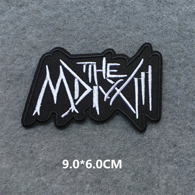 Black and white logo patch with text on a gray background
