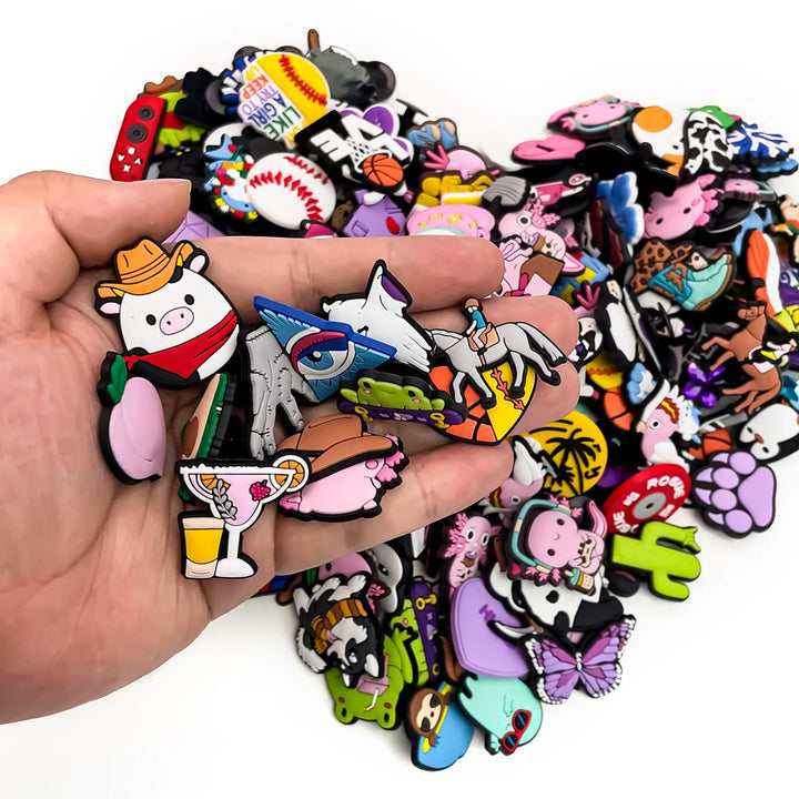 Hand holding a collection of colorful cartoon-style shoe charms  with a white background