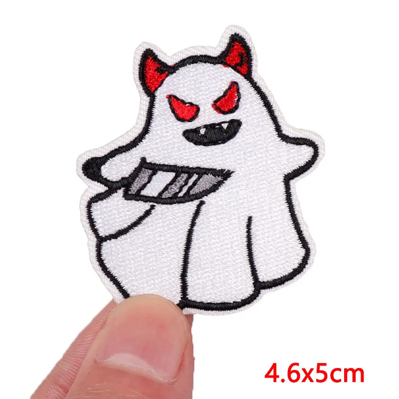 Embroidered patch of a ghost with red eyes held by a finger on a white background