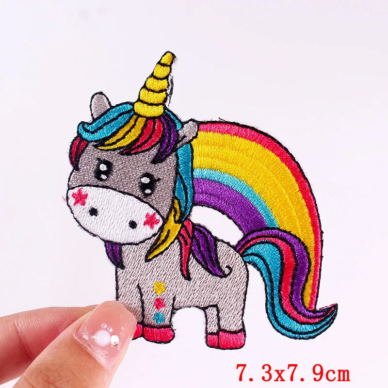 Colorful unicorn patch held by a hand with dimensions indicated.