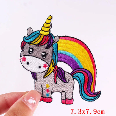 Colorful unicorn patch held by a hand with dimensions indicated.