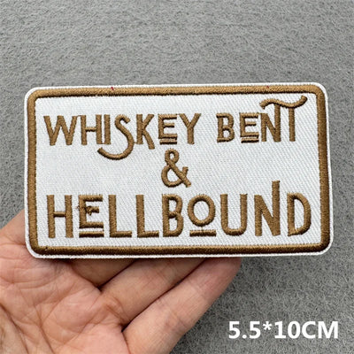 Embroidered patch with 'Whiskey Bent & Hellbound' text held in a hand against a gray background.