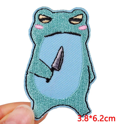 Blue cartoonish creature patch held by a hand with measurement label