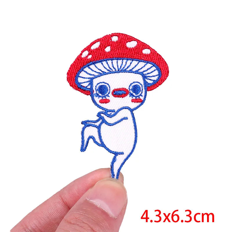 Embroidered patch of a cartoon mushroom held between fingers with size label &