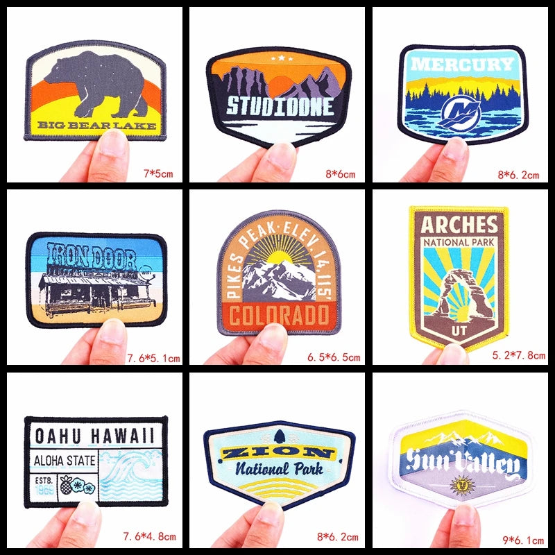 Collection of various stickers held by fingers, showcasing different designs and sizes.
