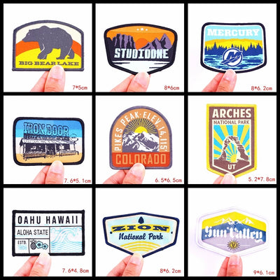 Collection of various stickers held by fingers, showcasing different designs and sizes.