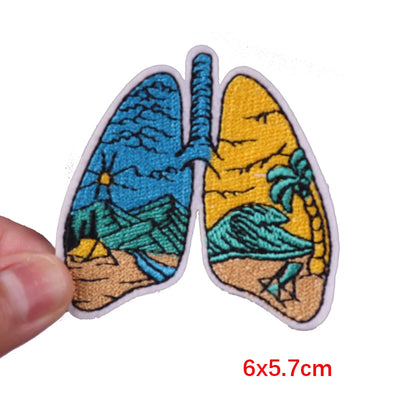 Patch designed like lungs with nature-themed illustrations held by a hand on a white background.